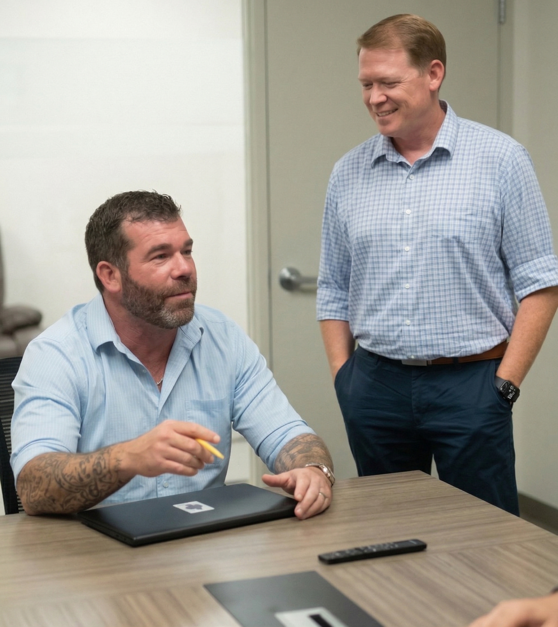 Two professionals in a modern conference room discussing roofing solutions at OpenbooQ
