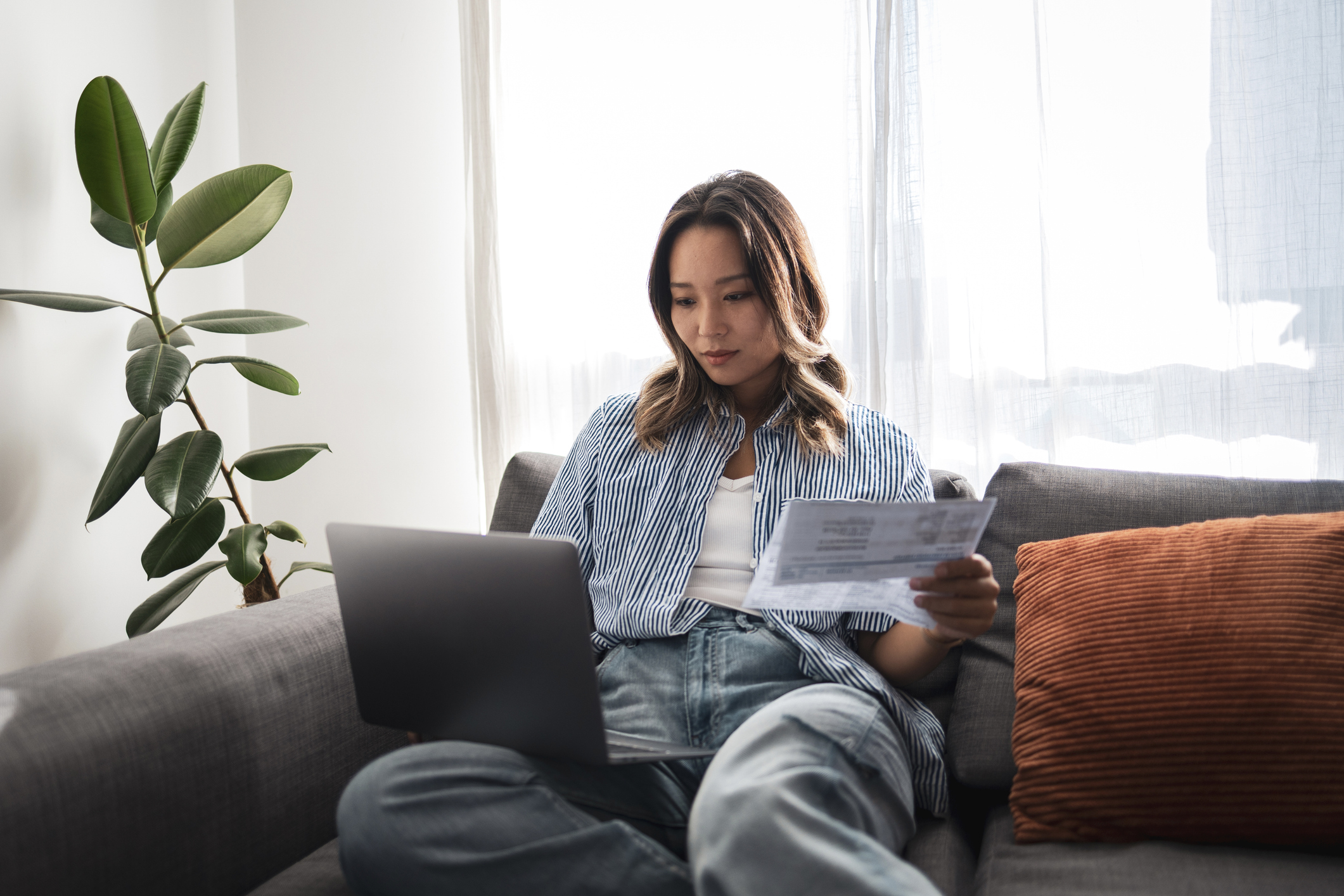 Woman using OpenbooQ platform on laptop for roofing estimate